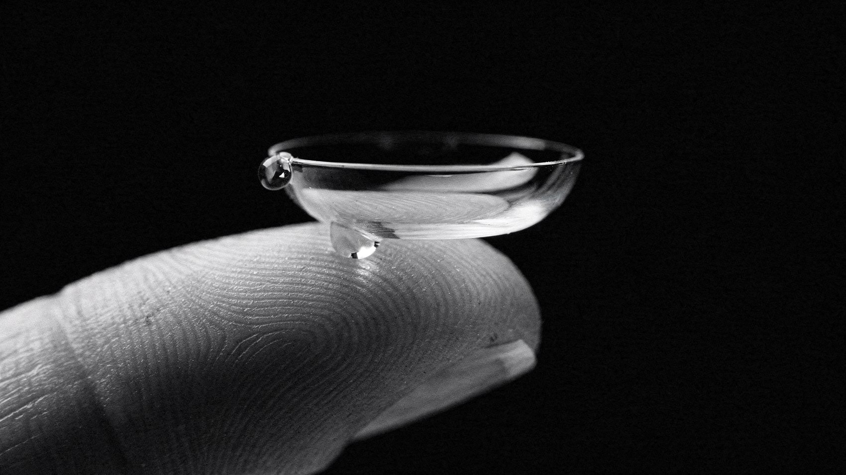 A daily disposable contact lens on a fingertip